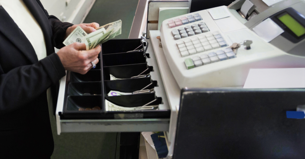 Dishonest employee taking money from a cash drawer